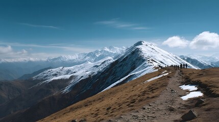 A group of hikers journeys along a rugged mountain ridge showcasing snow capped peaks under a clear expansive blue sky
