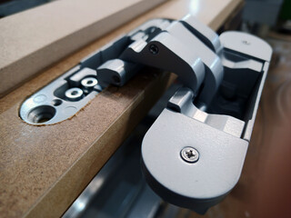 a milled hole for a door closer in a door frame. close-up of furniture production. © AlMacro