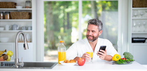 Healthy nutrition mature man. Aged man with healthy products at kitchen. Handsome 50s Senior Man...