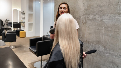Stylist working on long hair at a modern salon during a busy afternoon