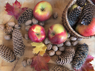 top view on bright red apples, walnuts and autumnal leaf on wooden background still life autumnal food