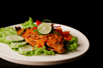 Straight On Zoomed In View of Ikan Bakar Balado grilled fish with chilli sauce in fine dining restaurant plating indonesian dish