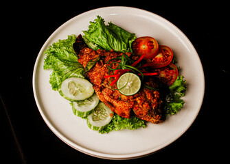 Overhead Top View of Ikan Bakar Balado grilled fish with chilli sauce in fine dining restaurant plating indonesian dish