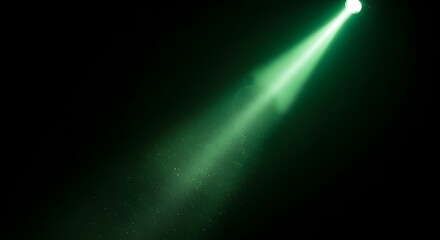 Green spotlight shining down in the darkness with dust particles floating around