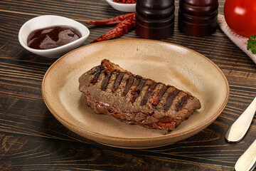 Grilled beef striploin steak with sauce