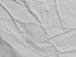 Crumpled white paper sheet with detailed wrinkles and rough texture. Abstract white paper surface for backgrounds. Paper background with copy space for text.