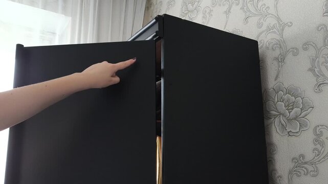 Close-up of a broken close-up of a close-up cabinet door hinge. The cabinet door is hanging