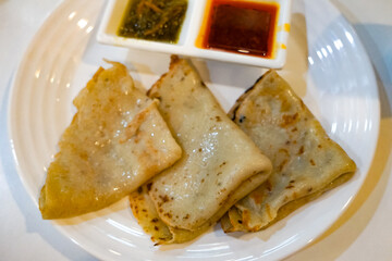 Lempeng (Pancakes) with Red and Green Sambal on White Plate