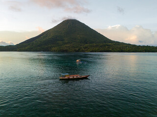 A boat with volcano background in Banda Islands, Central Maluku, Indonesia