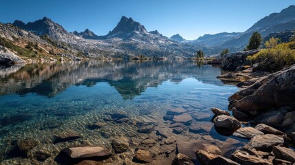 Breathtaking lakeside view surrounded by majestic mountains under a clear blue sky.