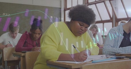Writing African American student in yellow top taking notes in classroom, with projected bar charts