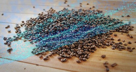 Displaying roasted coffee beans scattering across wooden tabletop, with turquoise digital artifacts