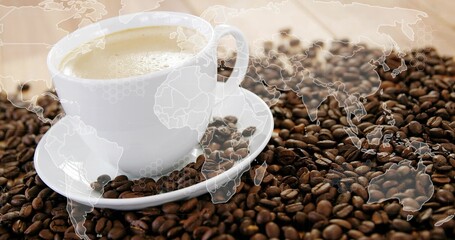 White ceramic cup with saucer holding frothy coffee on beans strewn tabletop, world map overlay