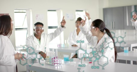 Chinese student wearing lab coat and goggles, raising hand in lab, with test tubes, copy space