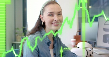Analyzing woman reviewing charts on monitors at modern office, with VR headset and potted plant