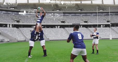 Lifting rugby jumper catching ball on stadium pitch, with goal posts, striped jerseys and cleats