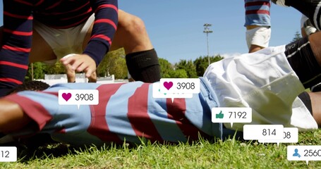 Lying rugby player in striped jersey and white shorts on grassy field, with social media icons