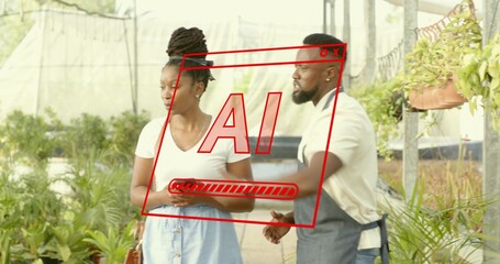 Holding small pot woman and gesturing man wearing dark apron examining seedling tray in nursery