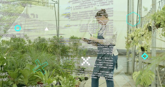 Holding tablet, horticultural workers monitoring potted plants in greenhouse, with data overlay - Powered by Adobe