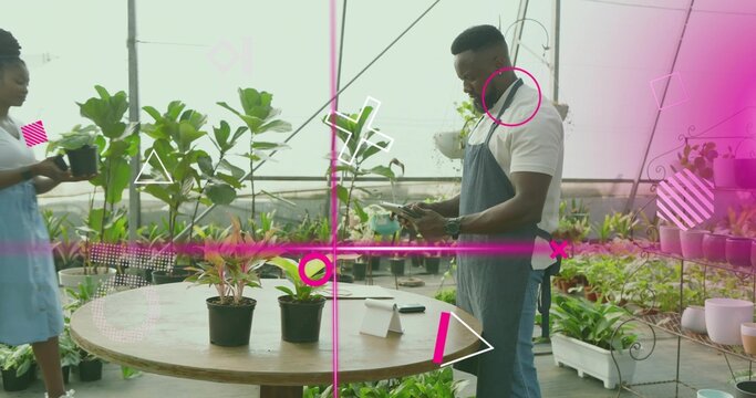 Holding watering can and checking phone, staff wearing aprons tending greenhouse, pink overlays - Powered by Adobe