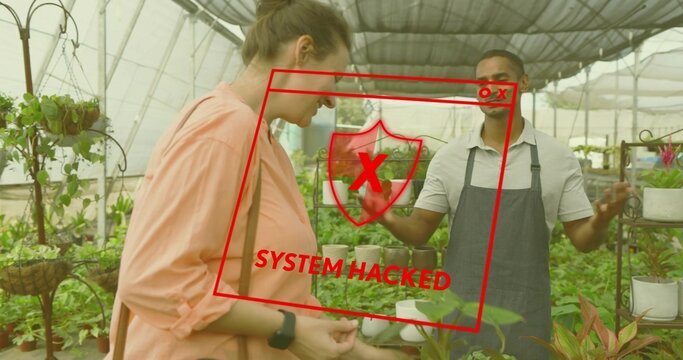 Holding small plant, vendor guiding shopper in coral blouse through greenhouse with potted plants