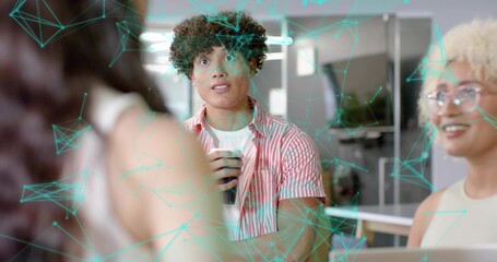 Holding male in striped shirt sipping disposable cup at office table, laptop and turquoise overlay