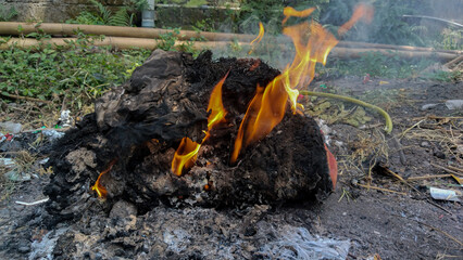 Burning dry trash with flames and smoke outdoors