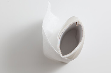 A roll of toilet paper is unrolled on a white surface