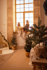 young couple sitting in front of christmas tree