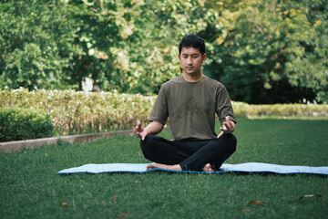 Asia man exercising practicing yoga in garden	