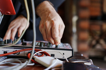 Hands adjusting audio equipment in a vibrant setting