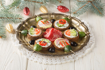 Christmas sandwich balls with cream cheese and fresh vegetables close-up in a plate on the table. Horizontal