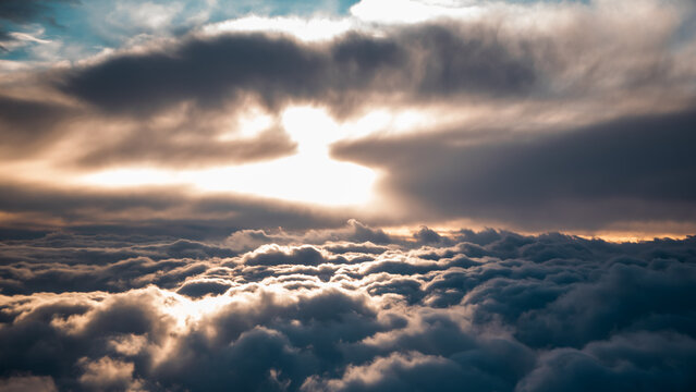 view from the airplane window to mountains clouds and blue sky