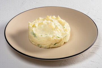 Creamy mashed potatoes with herbs served on a simple plate ready for a hearty meal