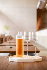 Iced tea in a glass jug on a wooden table in a restaurant. Stylish modern restaurant, minimalist style
