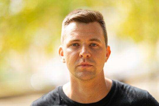 Young man posing with serious expression outdoors