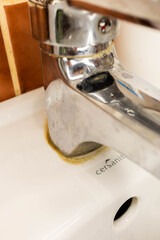 A close-up photo of plaque on the surface of a sink, and how to remove plaque from a faucet.