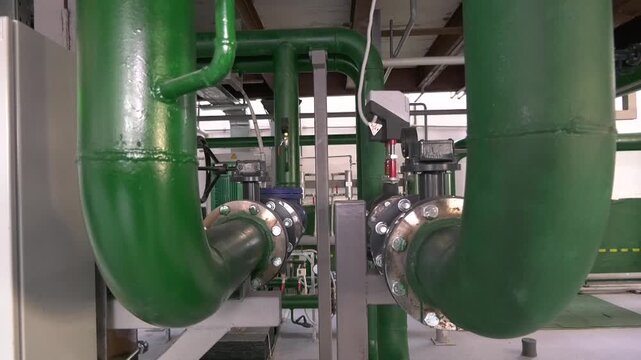 Large pipes in the mini-boiler room. Equipment of the mini-boiler room from the inside. Production and transportation of thermal energy and hot water. District heating.