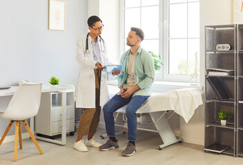 Woman doctor or nurse conducts consultation for patient in hospital, offering medical care,...