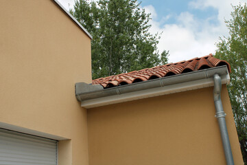 Gouttière zinc gris sur la façade de la maison, descentes et lambris de sous-face en PVC blanc