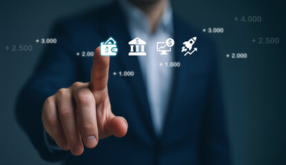 Businessman touching glowing virtual finance icons symbolizing digital banking and financial growth.