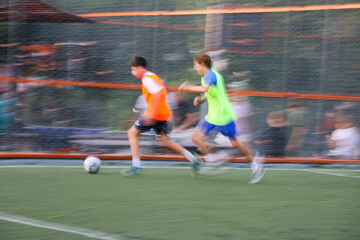 teens boys plays football at a sports school .Blur
