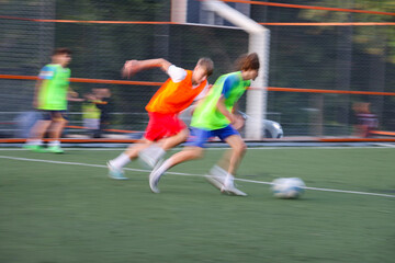 teens boys plays football at a sports school .Blur