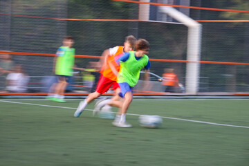 teens boys plays football at a sports school .Blur