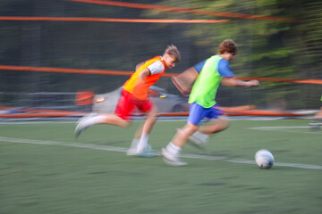 teens boys plays football at a sports school .Blur