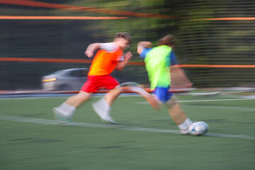 teens boys plays football at a sports school .Blur