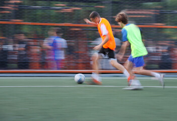 teens boys plays football at a sports school .Blur