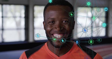 At start athlete in gym standing while commerce icons fading, connecting, highlighting sale 50% - Powered by Adobe