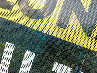 Close-up view at One Way Vision sticker film with dot pattern on glass. White, yellow, and black concept design