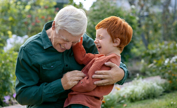Happy boy enjoying leisure time with grandfather in park
